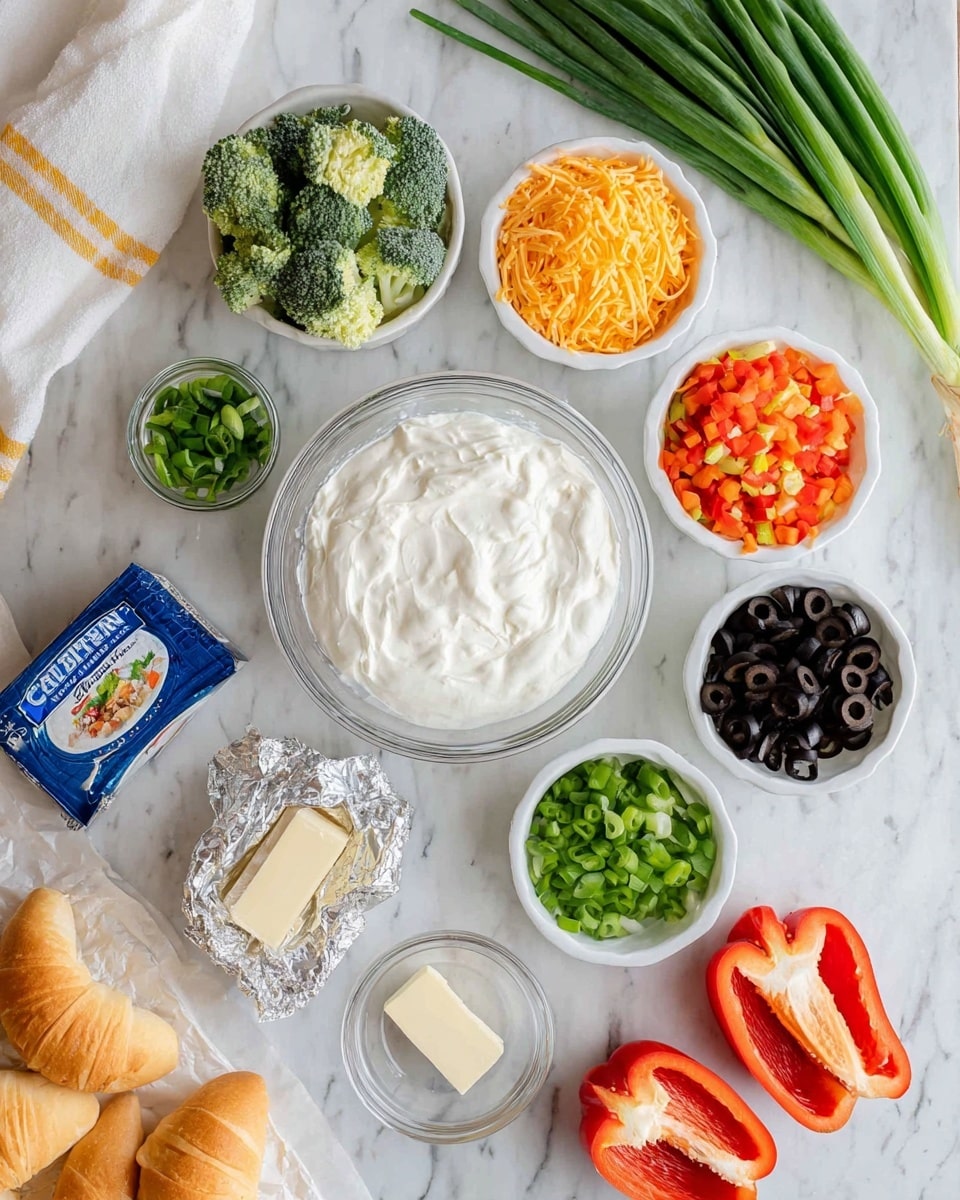 The image shows a flat lay of various ingredients arranged neatly on a white marbled surface. At the center is a clear glass bowl filled with thick, white sour cream or cream cheese mixture. Surrounding it are small white bowls with shredded cheddar cheese (orange), chopped green onions (light green), steamed broccoli florets (dark green), shredded carrots (orange), a mix of chopped green and red bell peppers, and black olives. There is also a partially opened block of cream cheese wrapped in foil and a small glass dish containing a small amount of butter. At the bottom, two halves of a red bell pepper and a green bell pepper are placed side by side. A blue box of crescent rolls is near the bottom left corner, and a bundle of fresh green onions lies at the top left. A white towel with a yellow stripe is partially visible on the upper right. The whole setup is clean and bright, capturing fresh ingredients. Photo taken with an iphone --ar 4:5 --v 7