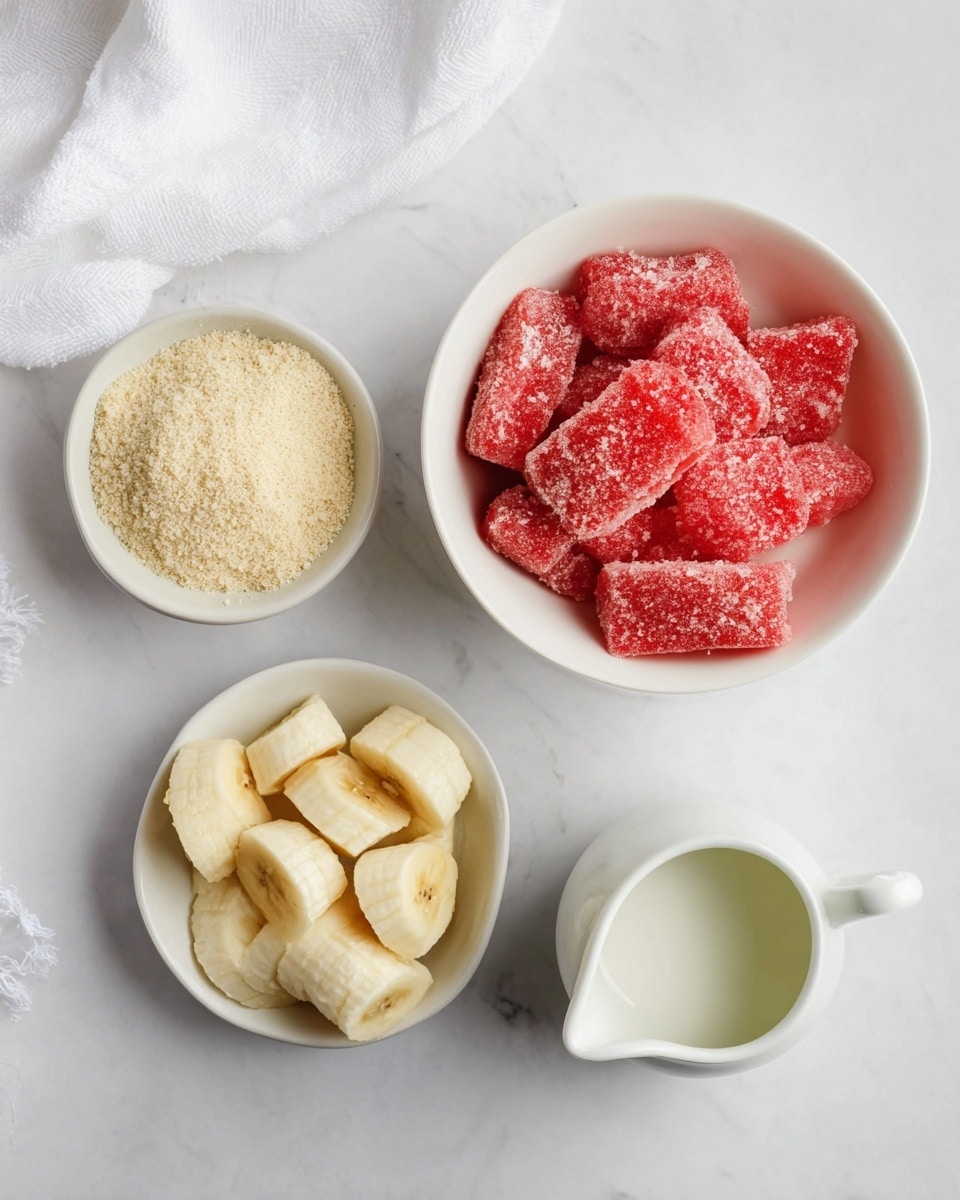 Three white bowls sit on a white marbled surface. The top left bowl holds a light beige powder with a crumbly texture, piled loosely. To the right, a larger white bowl is filled with bright red frozen watermelon chunks covered lightly with frost. Below, another white bowl contains four pale yellow banana pieces with soft textures. Near the bottom right corner, a white pitcher with a handle is filled with a light green liquid. A white cloth is partially visible on the top left edge. Photo taken with an iphone --ar 4:5 --v 7