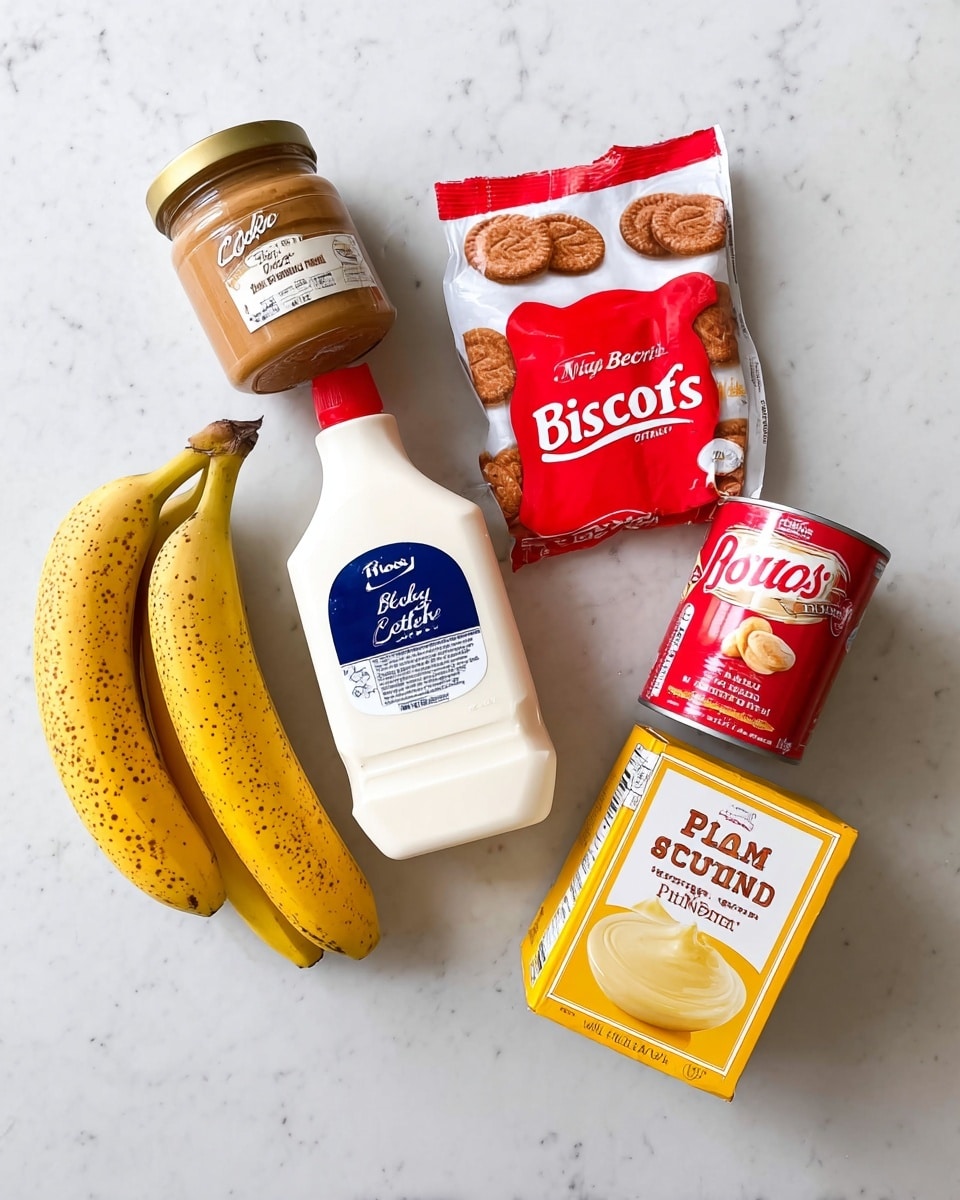The image shows six items arranged on a white marbled surface: a bunch of three yellow bananas with brown spots on the left side, a jar of light brown cookie butter spread with a gold lid below the bananas, a white plastic bottle of heavy whipping cream with a red cap and a blue label in the center, a white and red packet of Biscoff cookies at the top right, a red and white can of sweetened condensed milk to the right of the cream, and a small box of vanilla Jell-O pudding mix with a yellow creamy texture image on the bottom right photo taken with an iphone --ar 4:5 --v 7