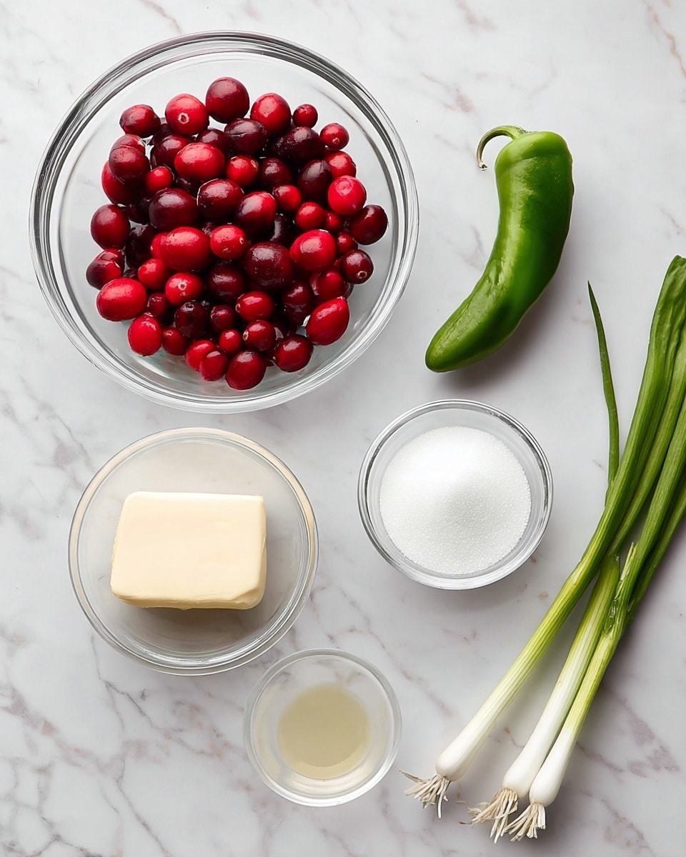 The image shows seven cooking ingredients arranged on a white marbled surface. Starting from the top left, there is a clear glass bowl filled with shiny, deep red cranberries. To the right, a single green chili pepper rests horizontally, showing its smooth skin. Below the chili, a small clear bowl holds a white creamy ingredient. To the right of this, another clear bowl contains white granulated sugar, and below it, a smaller clear bowl has a small amount of fine white salt. Near the bottom left, a stick of butter wrapped in silver foil lies horizontally. At the bottom center is a tiny clear cup with a small amount of light yellow liquid. Finally, on the far right, two green onions with fresh white bulbs and long green stalks are placed diagonally. Photo taken with an iphone --ar 4:5 --v 7